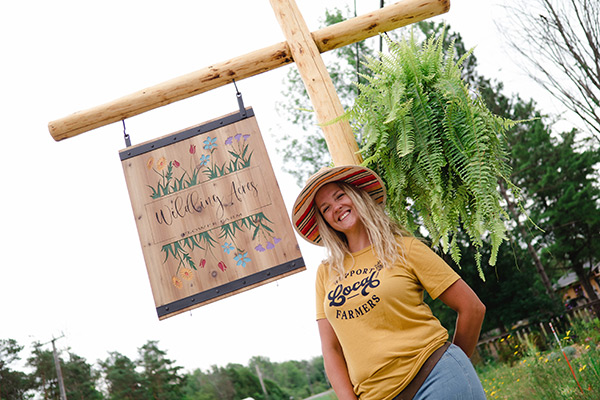 Wildling Acres owner standing by their sign