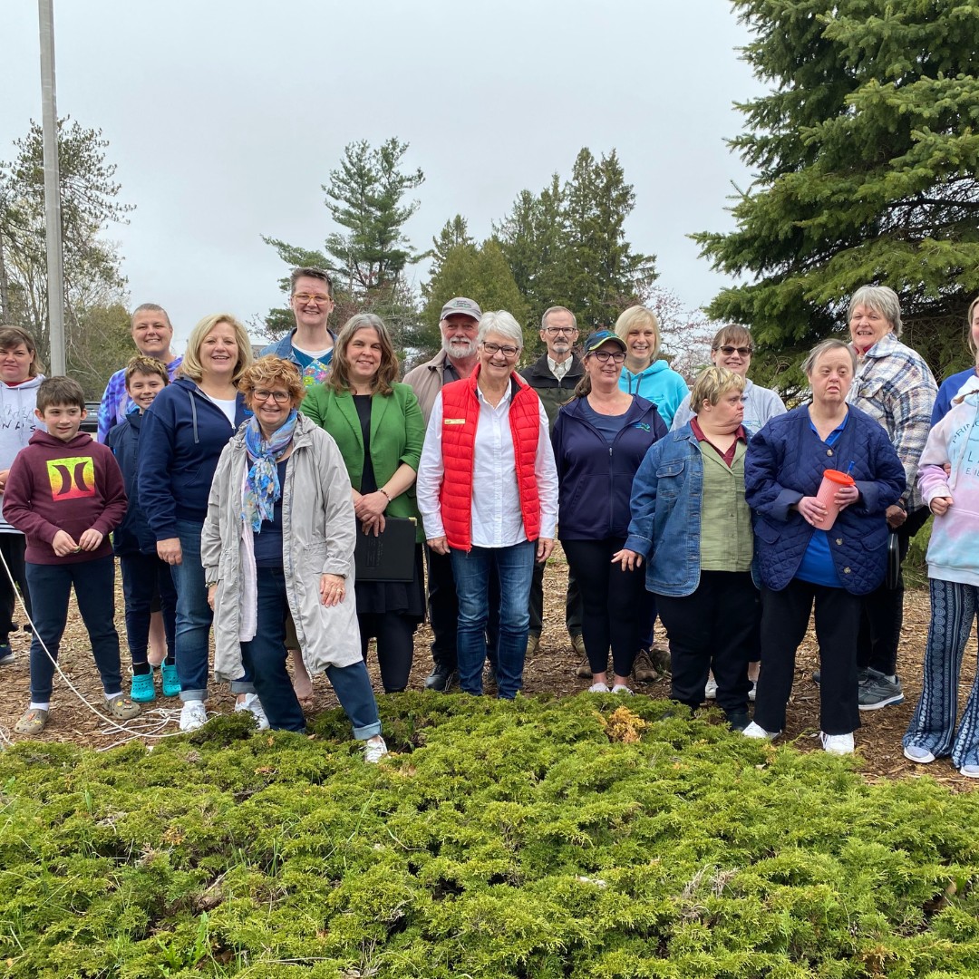 Mayor, Council, and members of Community Living posing at the flagpoles