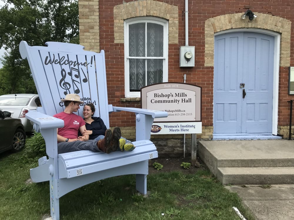 Couple sitting in over-sized adirondack chair in Bishops Mills