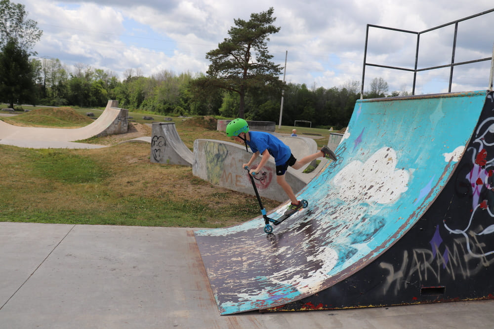 boy riding a scooter down a ramp